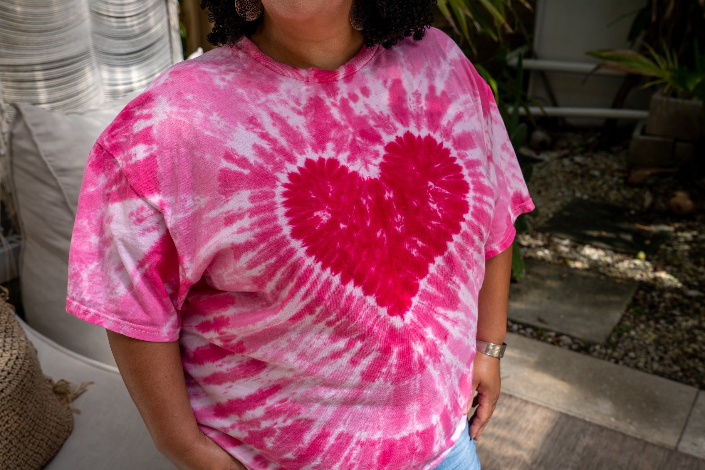 Close-up of the hand-dyed pink heart tie-dye tee showing the dye detail