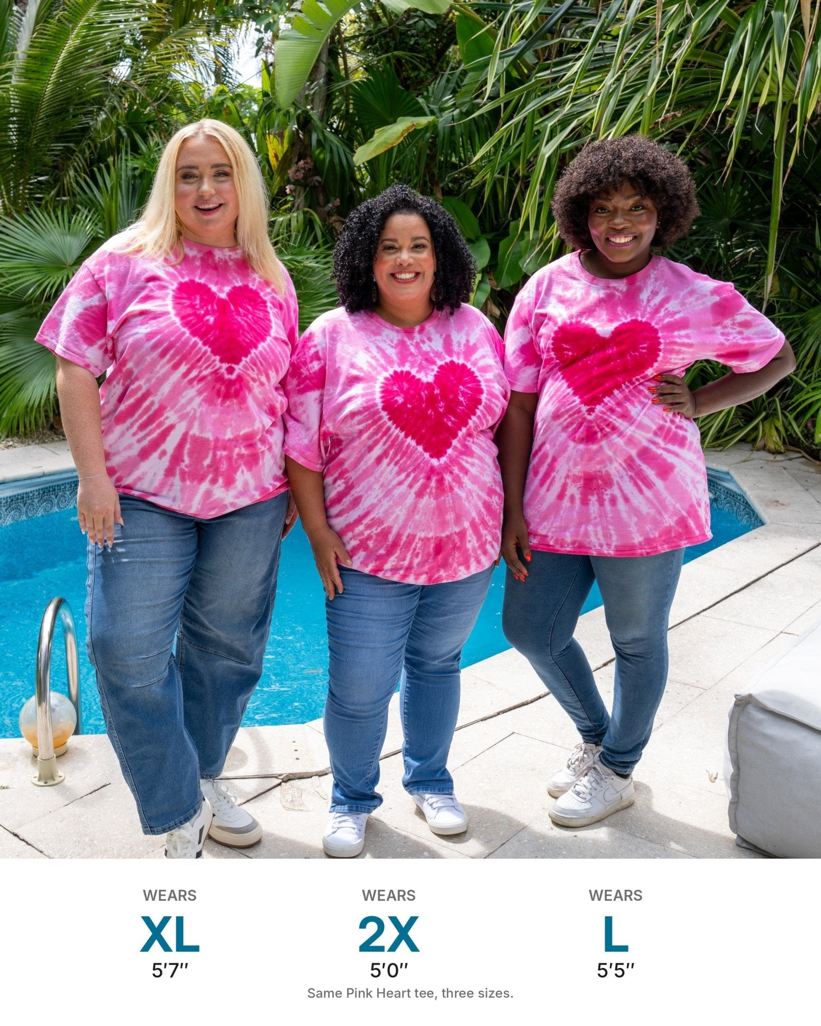 What each size looks like: three models in the same Pink Heart tie-dye tee - XL at 5'7", 2X at 5'0", L at 5'5"