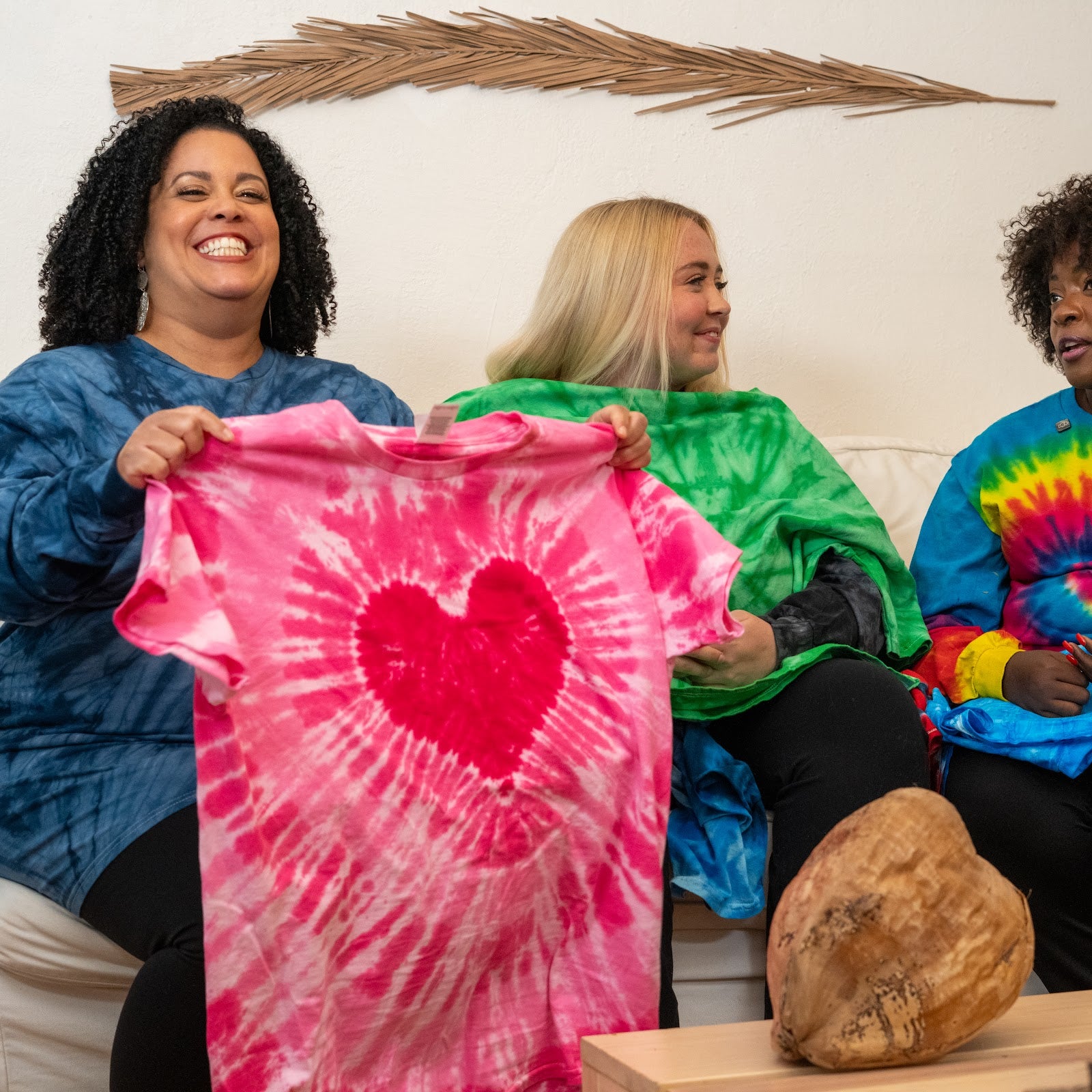 New arrivals - friends holding up a pink heart tie-dye tee